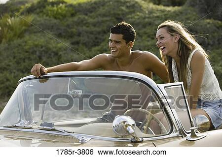 Young couple sitting in antique convertible car View Large Photo Image Stock Photograph - Young couple sitting in antique convertible car. Fotosearch