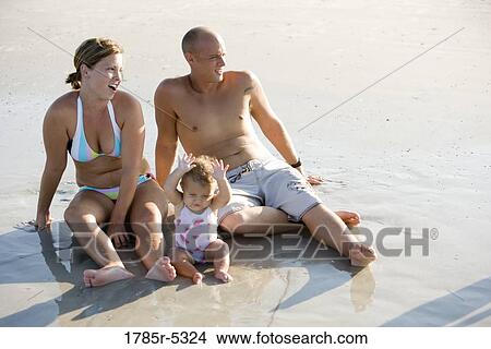 Young family vacationing at the beach View Large Photo Image Picture - Young family vacationing at the beach. Fotosearch