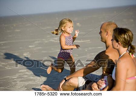 Stock Image - Young family vacationing at the beach. Fotosearch