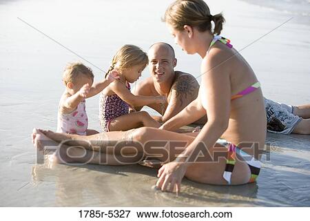 Young family vacationing at the beach View Large Photo Image Stock Photo - Young family vacationing at the beach. Fotosearch