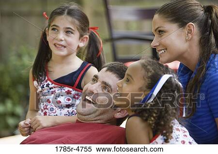 Young family with two girls on backyard patio looking away View Large Photo Image Stock Photography - Young family with two girls on backyard patio looking away. Fotosearch