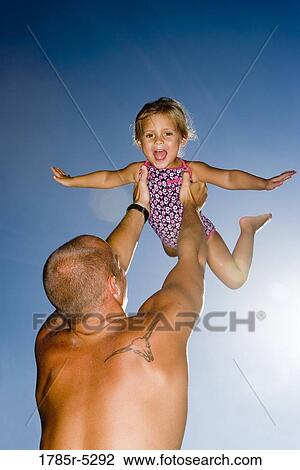 Young father holding daughter up in the air View Large Photo Image Stock Image - Young father holding daughter up in the air. Fotosearch