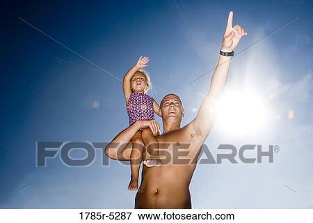 Young father holding daughter up on his shoulder while pointing View Large Photo Image Stock Photo - Young father holding daughter up on his shoulder while pointing. Fotosearch