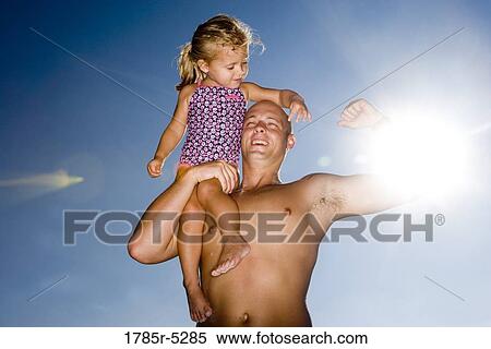 Young father holding daughter up on his shoulder while flexing his arm View Large Photo Image Stock Photography - Young father holding daughter up on his shoulder while flexing his arm. Fotosearch