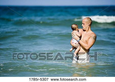 Young father playing with young daughter in the ocean View Large Photo Image Stock Photo - Young father playing with young daughter in the ocean. Fotosearch