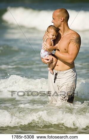 Young father playing with young daughter in the ocean View Large Photo Image Stock Photo - Young father playing with young daughter in the ocean. Fotosearch