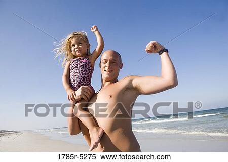 Stock Photography - Young father with daughter on shoulder flexing their muscles. Fotosearch