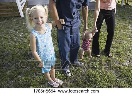 Picture - Young girl holding her father's arm. Fotosearch