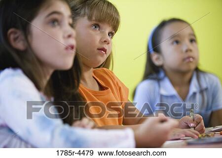 Young girls watching and listening attentively View Large Photo Image Stock Photo - Young girls watching and listening attentively. Fotosearch