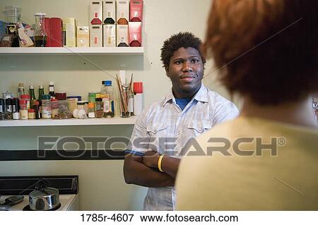 Young inter-racial couple conversing in a kitchen View Large Photo Image Stock Photo - Young inter-racial couple conversing in a kitchen. Fotosearch