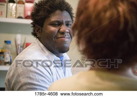 Young inter-racial couple conversing in a kitchen View Large Photo Image Stock Photo - Young inter-racial couple conversing in a kitchen. Fotosearch