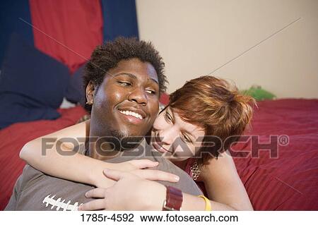 Young inter-racial couple in a bedroom View Large Photo Image Stock Image - Young inter-racial couple in a bedroom. Fotosearch