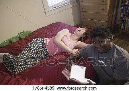 Young inter-racial couple in a bedroom View Large Photo Image Stock Photo - Young inter-racial couple in a bedroom. Fotosearch