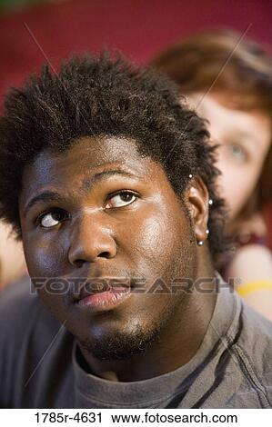 Stock Image - Young inter-racial couple looking up. Fotosearch