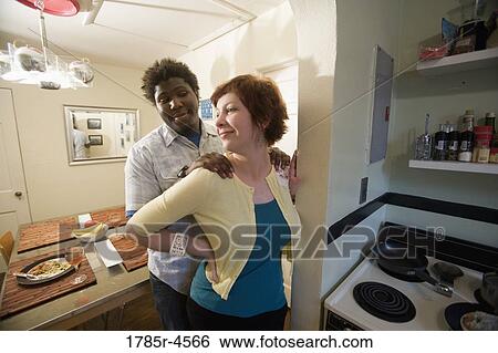 Young inter-racial couple posing affectionately by their kitchen View Large Photo Image Stock Photograph - Young inter-racial couple posing affectionately by their kitchen. Fotosearch