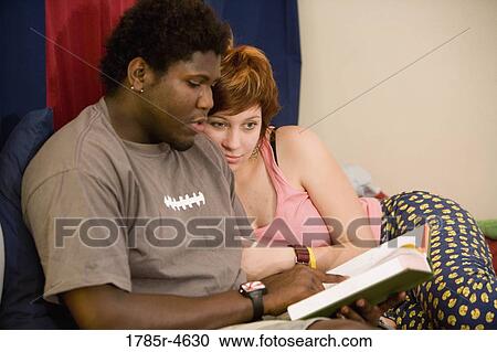 Young inter-racial couple reading a book together View Large Photo Image Stock Image - Young inter-racial couple reading a book together. Fotosearch