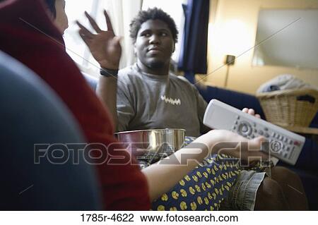 Young inter-racial couple sitting on a sofa View Large Photo Image Stock Image - Young inter-racial couple sitting on a sofa. Fotosearch