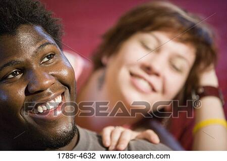 Stock Image - Young inter-racial couple smiling. Fotosearch
