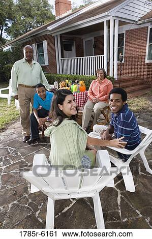 Young interracial couple enjoying backyard bbq with family View Large Photo Image Stock Image - Young interracial couple enjoying backyard bbq with family. Fotosearch
