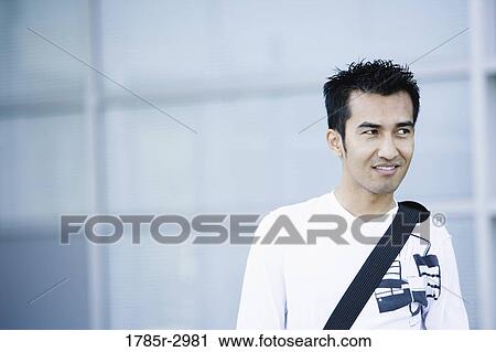 Young man looking away and smiling View Large Photo Image Stock Image - Young man looking away and smiling. Fotosearch