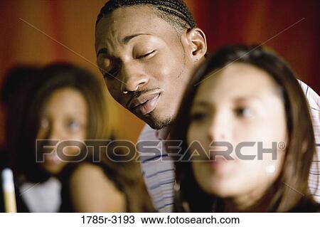 Young man ogling young woman in foreground View Large Photo Image Stock Image - Young man ogling young woman in foreground. Fotosearch