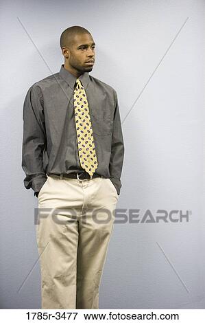 Young man standing with hands in pockets View Large Photo Image Stock Photo - Young man standing with hands in pockets. Fotosearch