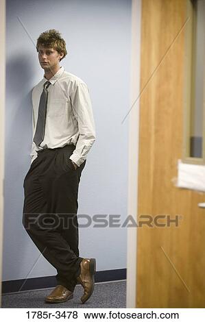Young man standing with hands in pockets View Large Photo Image Stock Photo - Young man standing with hands in pockets. Fotosearch