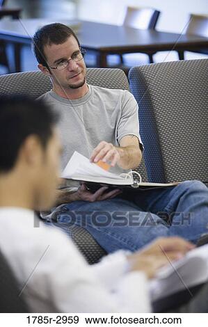 Young man with a notebook sitting on a sofa View Large Photo Image Stock Photo - Young man with a notebook sitting on a sofa. Fotosearch