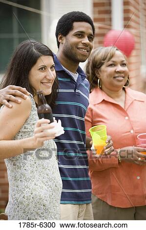 Stock Image - Young man with girlfriend and mother. Fotosearch