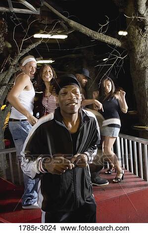 Young men and women in hip-hop fashion partying and dancing View Large Photo Image Picture - Young men and women in hip-hop fashion partying and dancing. Fotosearch