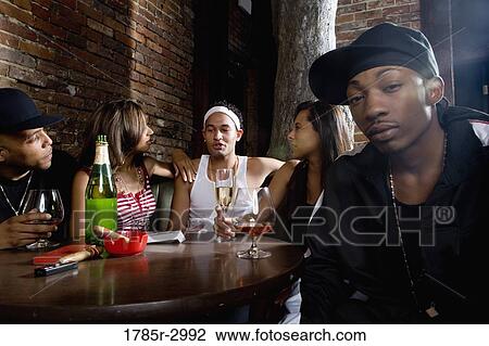 Young men and women in hip-hop fashion partying at a bar View Large Photo Image Stock Image - Young men and women in hip-hop fashion partying at a bar. Fotosearch