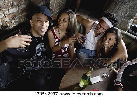 Young men and women in hip-hop fashion partying at a bar View Large Photo Image Stock Photo - Young men and women in hip-hop fashion partying at a bar. Fotosearch