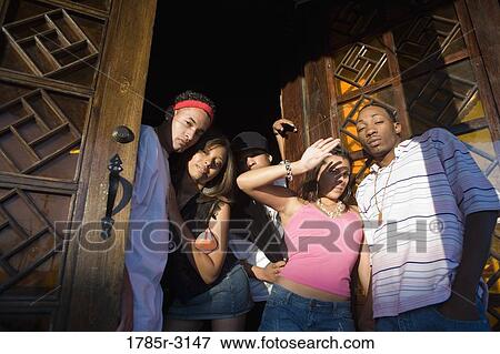 Young men and women in hip-hop fashion at entrance to a bar View Large Photo Image Stock Photo - Young men and women in hip-hop fashion at entrance to a bar. Fotosearch