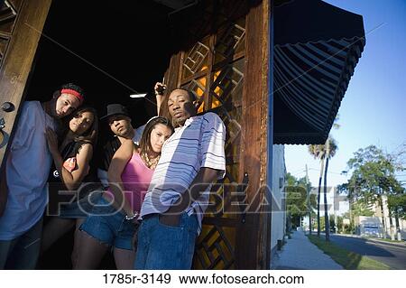 Young men and women in hip-hop fashion at entrance to a bar View Large Photo Image Stock Photo - Young men and women in hip-hop fashion at entrance to a bar. Fotosearch