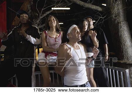 Stock Photography - Young men and women in hip-hop fashion partying and dancing. Fotosearch