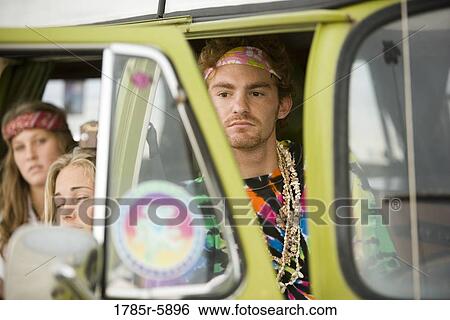 Stock Photograph - Young men and women in hippie fashion sitting in van. Fotosearch