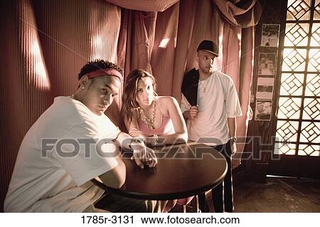 Young people in hip-hop fashion at a table View Large Photo Image Stock Image - Young people in hip-hop fashion at a table. Fotosearch
