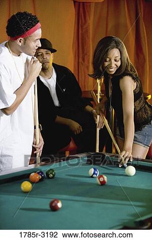 Young people shooting billiards in pool hall View Large Photo Image Stock Image - Young people shooting billiards in pool hall. Fotosearch