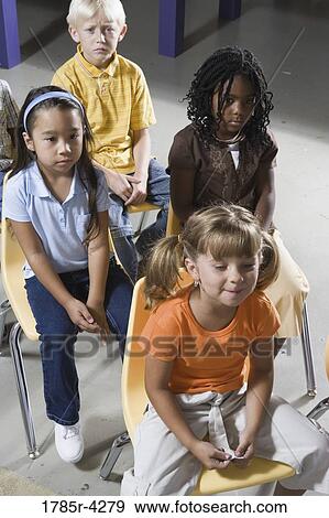 Young students sitting in a classroom View Large Photo Image Stock Photo - Young students sitting in a classroom. Fotosearch