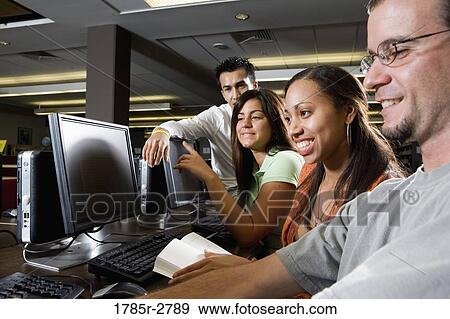 Young students using computers in the library View Large Photo Image Stock Photo - Young students using computers in the library. Fotosearch
