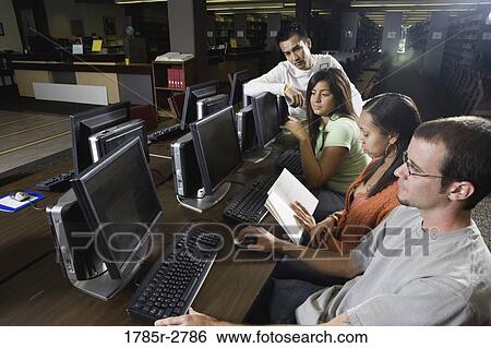 Young students using computers in the library View Large Photo Image Stock Photograph - Young students using computers in the library. Fotosearch