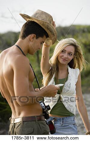 Young woman playing with hat on a man's head View Large Photo Image Stock Image - Young woman playing with hat on a man's head. Fotosearch