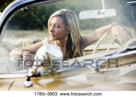 Young woman sitting in antique convertible car View Large Photo Image Stock Image - Young woman sitting in antique convertible car. Fotosearch