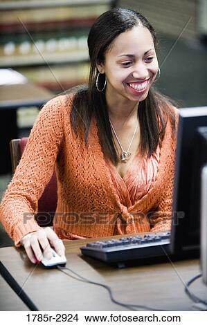 Young woman using computer with hand on mouse View Large Photo Image Picture - Young woman using computer with hand on mouse. Fotosearch