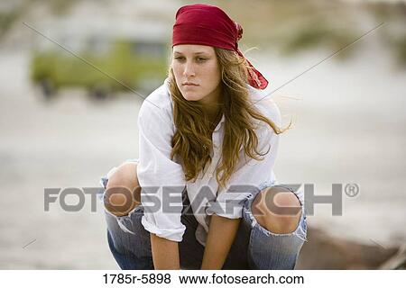 Stock Photo - Young woman with bandana crouching. Fotosearch