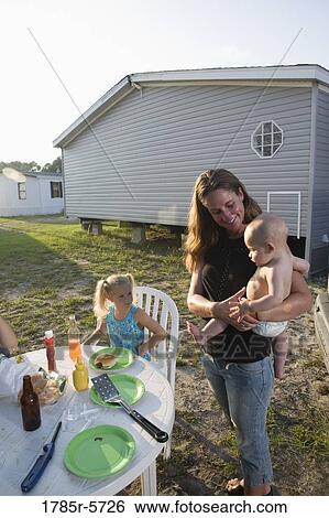 Young woman with children in backyard outside trailer home View Large Photo Image Stock Photograph - Young woman with children in backyard outside trailer home. Fotosearch
