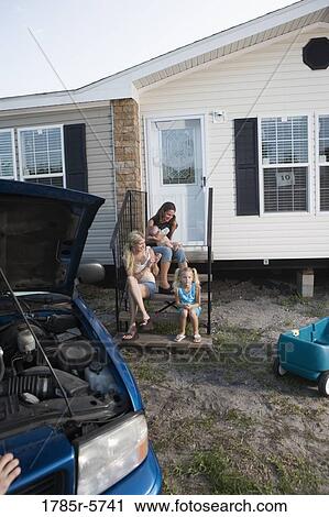 Young women and children sitting on front steps of trailer home View Large Photo Image Stock Image - Young women and children sitting on front steps of trailer home. Fotosearch