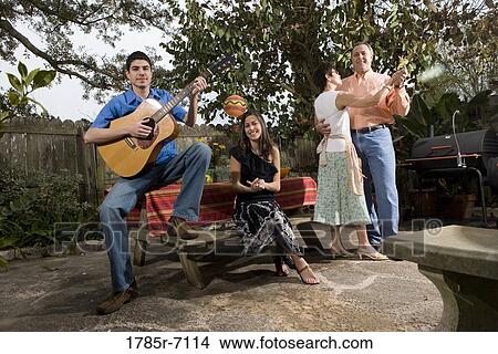 A Mexican-American family playing music and dancing in the backyard of their house View Large Photo Image Picture - A Mexican-American family playing music and dancing in the backyard of their house. Fotosearch
