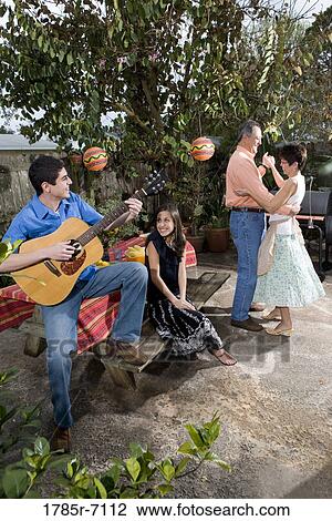 A Mexican-American family playing music and dancing in the backyard of their house View Large Photo Image Stock Image - A Mexican-American family playing music and dancing in the backyard of their house. Fotosearch