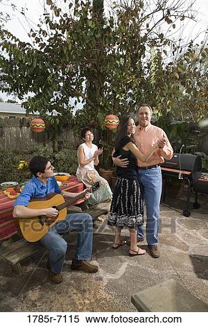 A Mexican-American family playing music and dancing in the backyard of their house View Large Photo Image Stock Photography - A Mexican-American family playing music and dancing in the backyard of their house. Fotosearch
